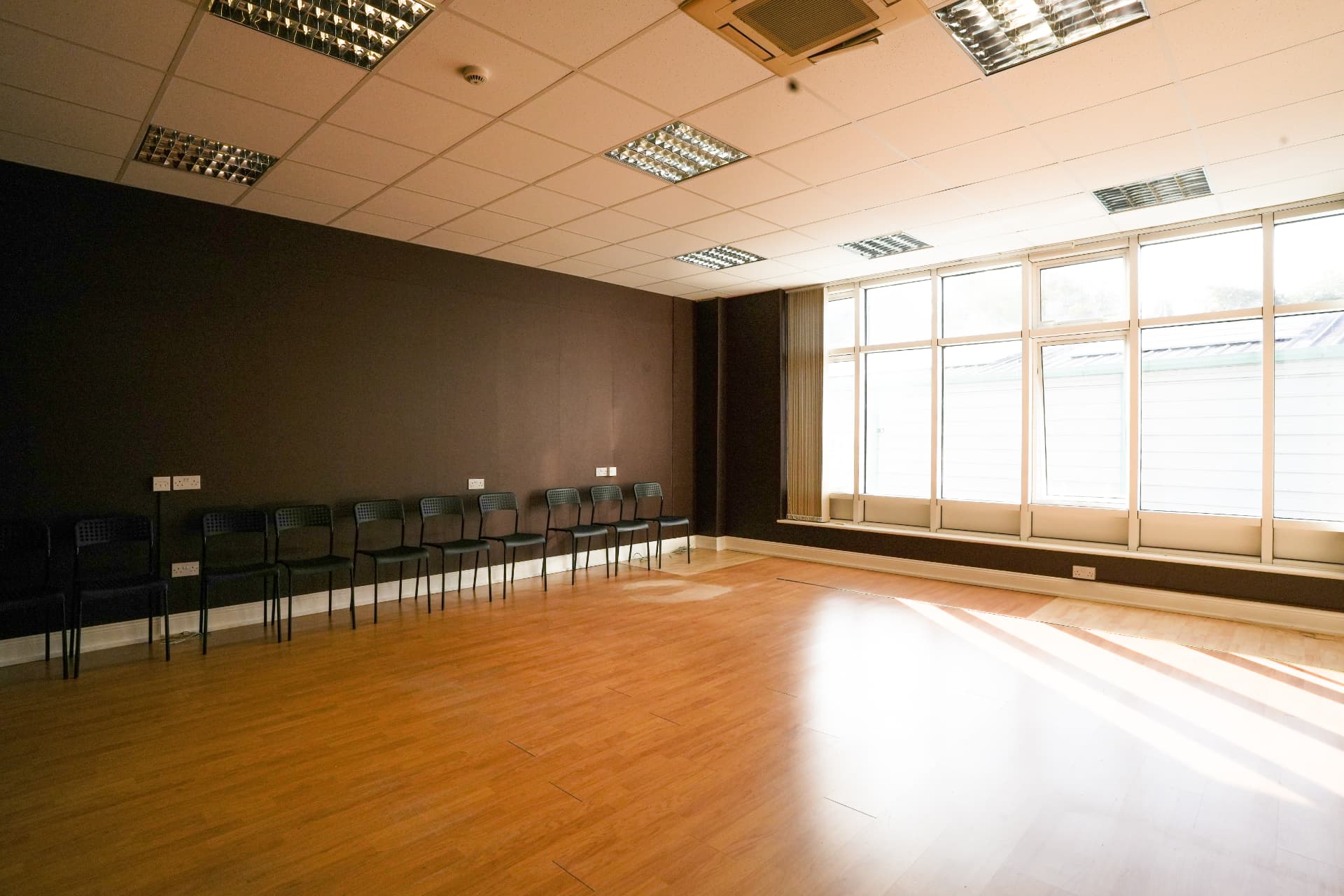 The open studio floor with chairs and a full wall of windows